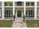 Covered porch with iron railing detail, columns, double doors, planters and stone floor at 4523 Fox Brook Ln, Charlotte, NC 28211