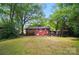 The backyard features a large grassy area, brick patio, and pergola for relaxing at 4647 General Pershing Dr, Charlotte, NC 28209