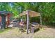 The backyard features a pergola with seating, barbeque grill, and mature trees for privacy at 4647 General Pershing Dr, Charlotte, NC 28209