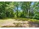 The backyard features mature trees, a large grassy area, and space to entertain at 4647 General Pershing Dr, Charlotte, NC 28209