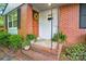 Inviting brick porch with a decorative wreath and potted plants near the home's entrance at 4647 General Pershing Dr, Charlotte, NC 28209