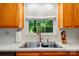The kitchen features a stainless steel sink and faucet with a view of the trees outside at 4647 General Pershing Dr, Charlotte, NC 28209