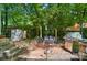 A brick patio features an outdoor kitchen with mature trees that provide privacy at 4647 General Pershing Dr, Charlotte, NC 28209