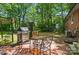The brick patio features a barbecue grill, outdoor seating, and mature trees for privacy at 4647 General Pershing Dr, Charlotte, NC 28209