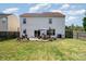 Backyard featuring a patio with a dining table, lawn, wooden fence, and a two-story house at 4711 Sunburst Ln, Charlotte, NC 28213