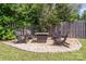 Fire pit area in backyard with four chairs, pea gravel, stone border, and wooden fence at 4711 Sunburst Ln, Charlotte, NC 28213