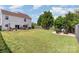 Large backyard featuring a fire pit area, lawn, patio, and a two-story house at 4711 Sunburst Ln, Charlotte, NC 28213