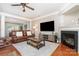Inviting living room featuring a fireplace, hardwood floors, and a comfortable leather sofa at 4711 Sunburst Ln, Charlotte, NC 28213