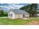 Home's rear exterior with a wooden deck, sliding glass door, and well-kept yard with a fire pit at 5052 Swinging Bridge Rd, Conover, NC 28613