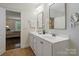 This bathroom has a double vanity with white cabinets and a view into the bedroom at 5663 Morris Hunt Dr, Fort Mill, SC 29708