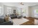 Bright bonus room featuring a sectional sofa and a treadmill. Hardwood flooring throughout at 5663 Morris Hunt Dr, Fort Mill, SC 29708