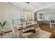 Bright dining area featuring a rustic wood table, bench seating, and modern light fixture, connecting to the kitchen at 5663 Morris Hunt Dr, Fort Mill, SC 29708