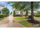 Charming home exterior with lush lawn, mature trees, manicured bushes, and a long driveway at 5663 Morris Hunt Dr, Fort Mill, SC 29708