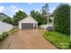 Detached garage, with a gray door, provides ample parking and storage, side yard with green shrubbery at 5663 Morris Hunt Dr, Fort Mill, SC 29708