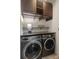 Efficient laundry area featuring sleek, modern washer and dryer units with upper cabinets at 5663 Morris Hunt Dr, Fort Mill, SC 29708