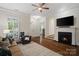 Bright and airy living room featuring a fireplace, hardwood floors, and ample natural light at 5663 Morris Hunt Dr, Fort Mill, SC 29708