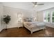 This main bedroom showcases hardwood floors, a ceiling fan, neutral decor, and plantation shutters at 5663 Morris Hunt Dr, Fort Mill, SC 29708