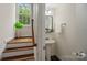 This powder room features a pedestal sink with a view of stairs and a window at 5663 Morris Hunt Dr, Fort Mill, SC 29708