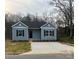 Charming one-story home featuring blue siding, black shutters, a black front door, and a concrete driveway at 601 Queens Rd, Gastonia, NC 28052