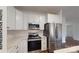 Bright kitchen with white cabinets, stainless steel appliances, marble countertops, and subway tile backsplash at 601 Queens Rd, Gastonia, NC 28052
