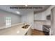 Modern kitchen with white cabinets, stainless steel appliances, marble countertops, and a breakfast bar with a sink at 601 Queens Rd, Gastonia, NC 28052