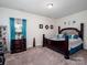 Comfortable bedroom features a dark wooden bed, ample natural light and simple decor at 6381 Trinity Crossing Cir, Kannapolis, NC 28081