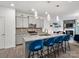 Modern kitchen boasts a granite island with seating, stainless steel appliances, and updated lighting fixtures at 6381 Trinity Crossing Cir, Kannapolis, NC 28081