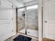 Shower with glass doors, tiled walls, and a built-in shelf at 6381 Trinity Crossing Cir, Kannapolis, NC 28081