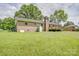 Spacious backyard with a brick house, wooden deck, chimney, and lush green grass at 6573 Weldon Nw Cir # 22, Concord, NC 28027