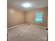 This bedroom features neutral paint and carpet with natural light from the window at 6573 Weldon Nw Cir # 22, Concord, NC 28027