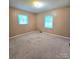 Cozy bedroom with two windows, carpet, and neutral walls at 6573 Weldon Nw Cir # 22, Concord, NC 28027