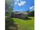 Rear view of brick home with a well-maintained lawn and landscaping, and space for outdoor activities at 6573 Weldon Nw Cir # 22, Concord, NC 28027