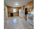 Kitchen boasts bright white appliances, wood cabinets, and tile floor at 6573 Weldon Nw Cir # 22, Concord, NC 28027