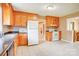 Functional kitchen with wood cabinets, tiled floor, white appliances, and ample counter space at 6573 Weldon Nw Cir # 22, Concord, NC 28027