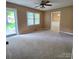 Cozy living room with neutral carpeting, ceiling fan, and natural light at 6573 Weldon Nw Cir # 22, Concord, NC 28027