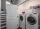 Convenient laundry area with modern washer and dryer units, storage shelves, and easy access to the staircase at 7455 Ivey Dr, Sherrills Ford, NC 28673