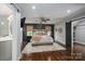 Spacious primary bedroom with hardwood floors, a ceiling fan, decorative rug, and barn door access at 7455 Ivey Dr, Sherrills Ford, NC 28673