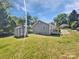 The home's backyard features an expansive lawn, a storage shed, and a small wooden deck at 905 Brookdale St, Kannapolis, NC 28083