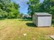 The backyard features green grass, trees, and a shed at 905 Brookdale St, Kannapolis, NC 28083