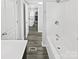 This is a bathroom with a tub, shower, sink, and door to the kitchen at 905 Brookdale St, Kannapolis, NC 28083