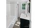 This well-lit bathroom features a vanity with sink, a tub with shower, and a bright window at 905 Brookdale St, Kannapolis, NC 28083
