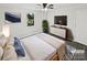 This is a bedroom with a bed, TV, dresser, plant, window, painting, ceiling fan, rug, and door at 905 Brookdale St, Kannapolis, NC 28083