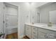 A bright bathroom with double vanity, a large mirror and framed by white cabinets and modern fixtures at 908 Westminster Dr, Statesville, NC 28677