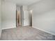 Spacious bedroom featuring neutral walls, carpet, and two white doors, with ample closet space at 908 Westminster Dr, Statesville, NC 28677