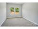 Neutral bedroom boasts natural light from two windows with a private wooded view at 908 Westminster Dr, Statesville, NC 28677