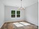 Bright dining room featuring wood floors, ample natural light, and elegant chandelier at 908 Westminster Dr, Statesville, NC 28677