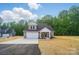Inviting two-story home with a manicured lawn, attached garage, and classic gray and white color scheme at 908 Westminster Dr, Statesville, NC 28677