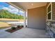 Covered porch detail showcasing exterior siding, stone accents, and a view of the surrounding landscape at 908 Westminster Dr, Statesville, NC 28677