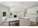 Kitchen island with stainless dishwasher, bright lighting, and open view to the fireplace at 908 Westminster Dr, Statesville, NC 28677