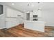 Bright, modern kitchen with white cabinets, island, stainless steel appliances, and wood floors at 908 Westminster Dr, Statesville, NC 28677
